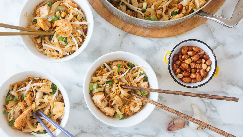 three bowls and big pan of pad thai