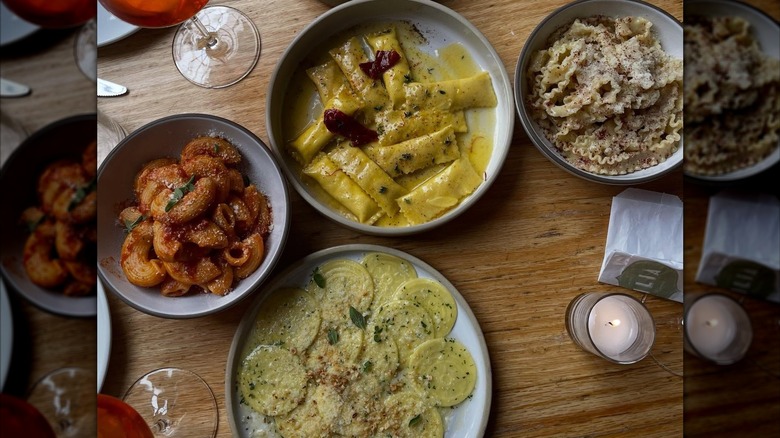 aerial view of wooden table at Lilia Italian restaurant in new york, with four pasta plates