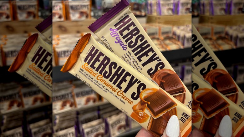 Person holding two new varieties of Hershey's candy bars.