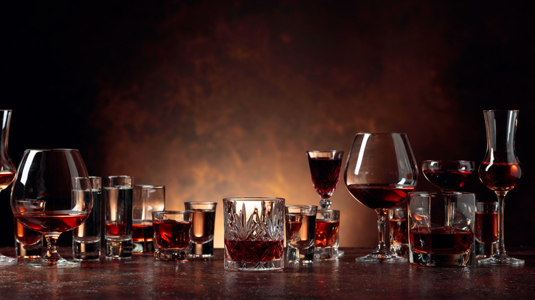 A variety of glasses with liquor on wooden surface