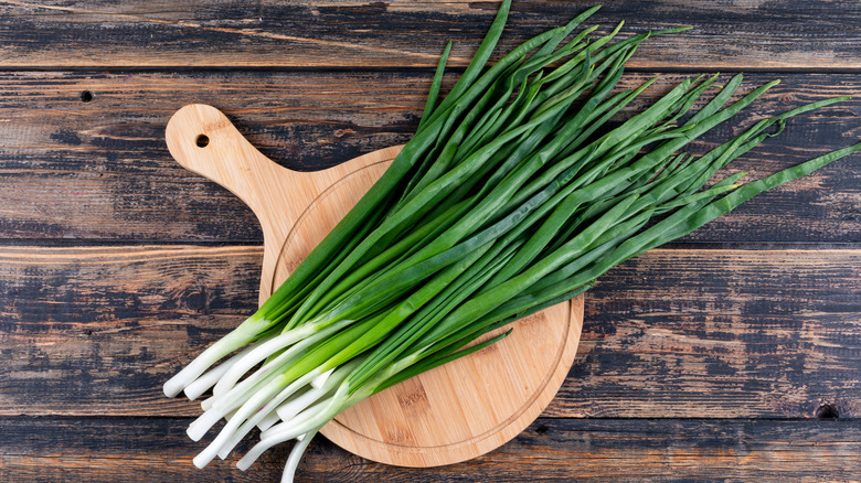 green onions on a wood cutting board