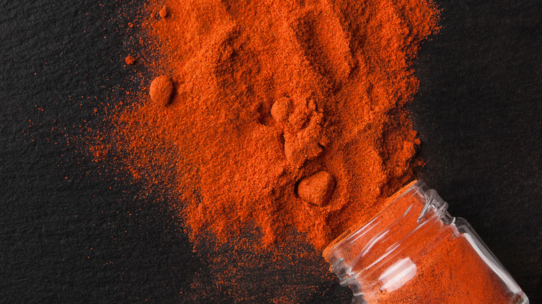 Red chili powder spilled on black surface