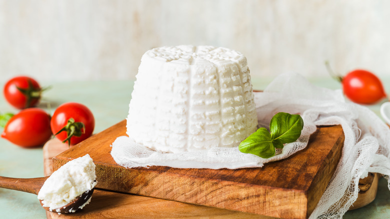 ricotta cheese on a wood board with tomatoes 