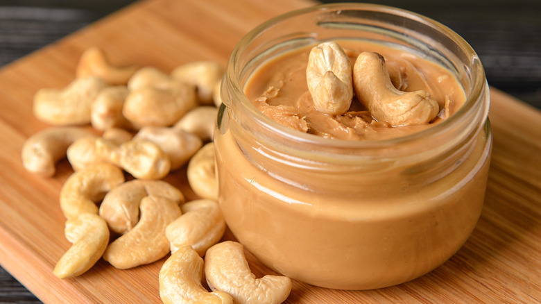 jar of cashew butter on wood cutting board