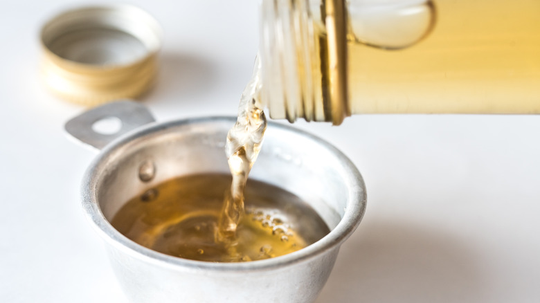white wine vinegar pouring into a measuring cup