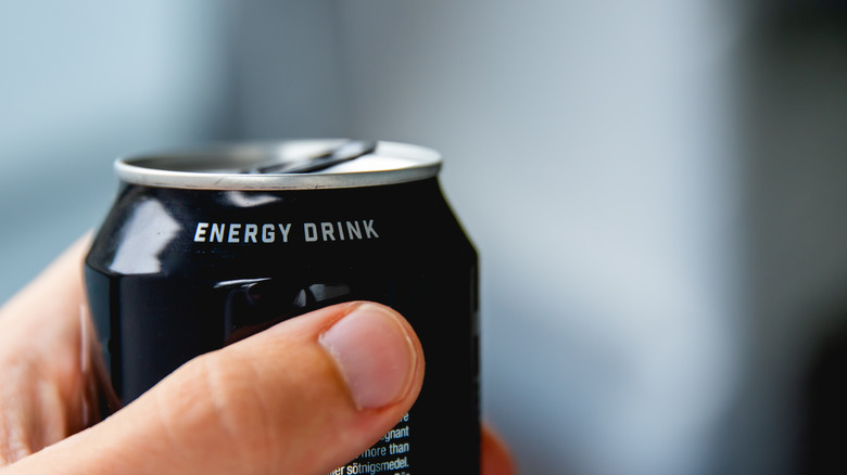 Closeup of hand holding can of energy drink