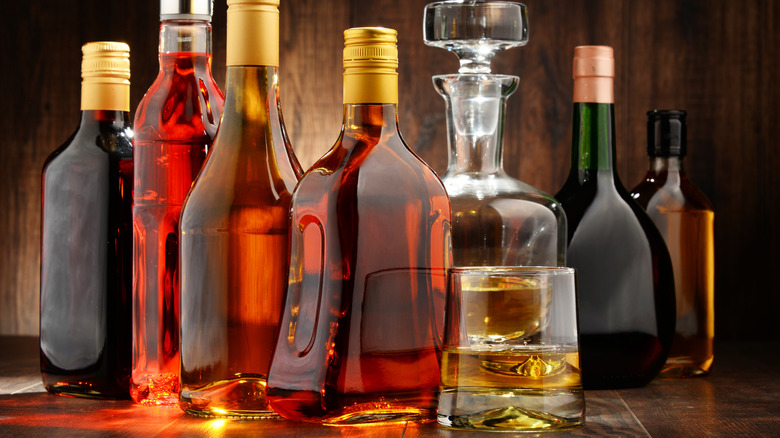 Bottles of spirits and a glass of brown liquor