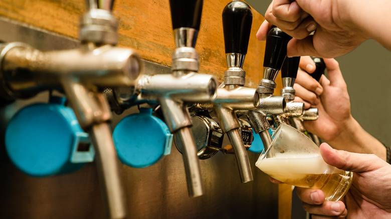 Hands pouring a draft beer