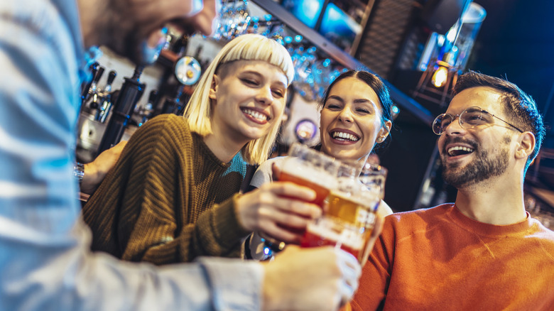Friends clinking beer glasses in brewery