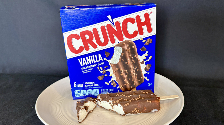 Crunch ice cream bar cut open on plate with box in background