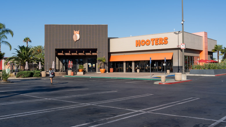 Exterior of a Hooters restaurant with empty parking lot