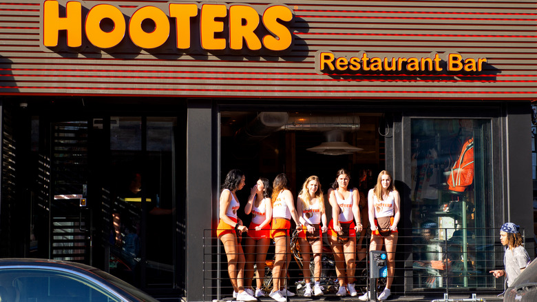 Hooters restaurant front with servers standing outside