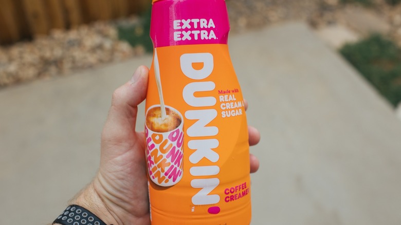 hand holding bottle of Dunkin' creamer