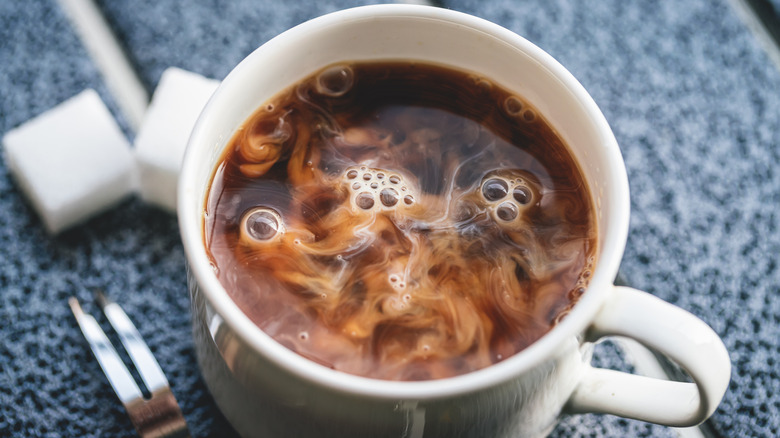 mug of coffee with creamer swirling throughout