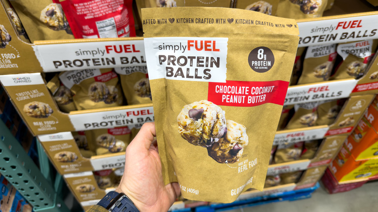 Hand holding SimplyFuel Protein Balls bag at Costco