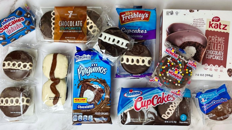 Packages of Creme Filled Chocolate Cupcakes from several brands, including Hostess, 7-Eleven, Mrs. Freshley's, Katz, Wonder, Pinguinos, Drake's, Little Debbie, Walmart, and Tastykake