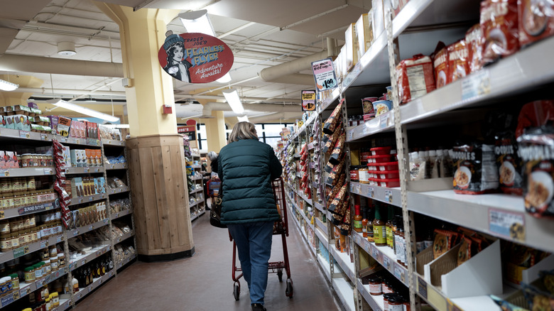 Shopper pushing a cart down the aisle at Trader Joe's