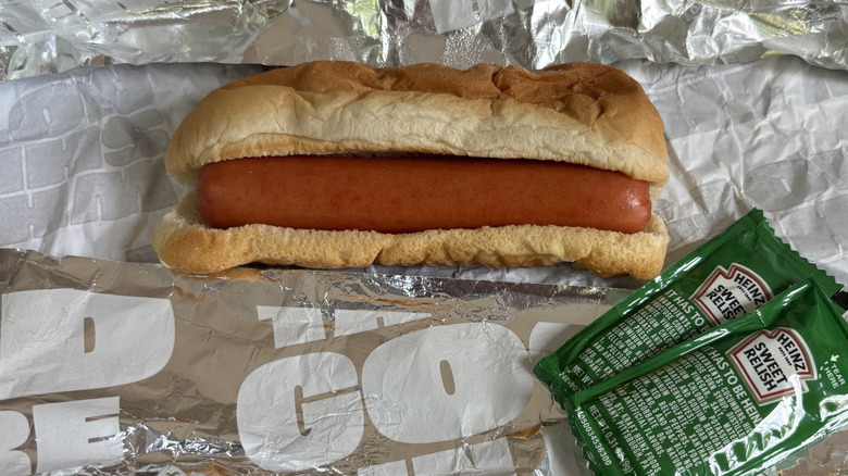 hot dog in wrapper with relish packets