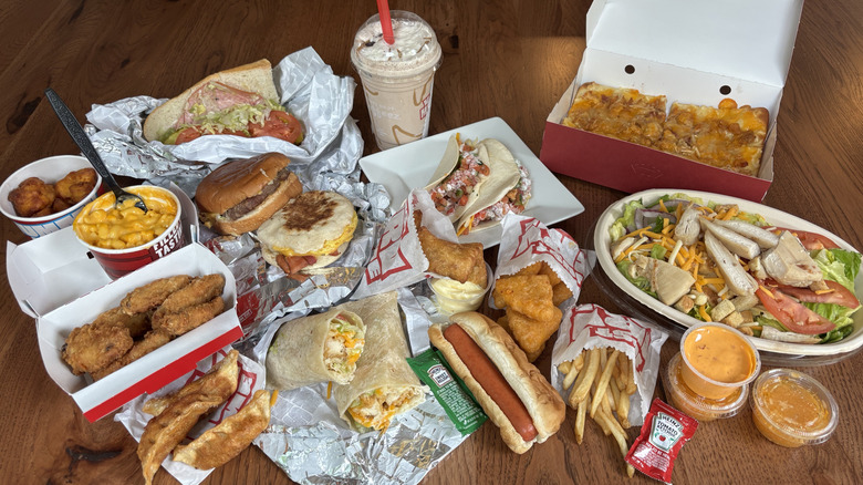 burger, flatbread, wings, fries, and other food from Sheetz laid on table