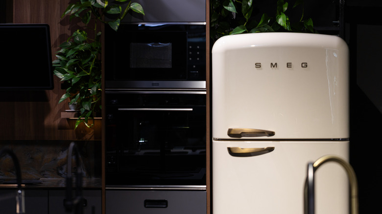 A white Smeg refrigerator in a dark kitchen