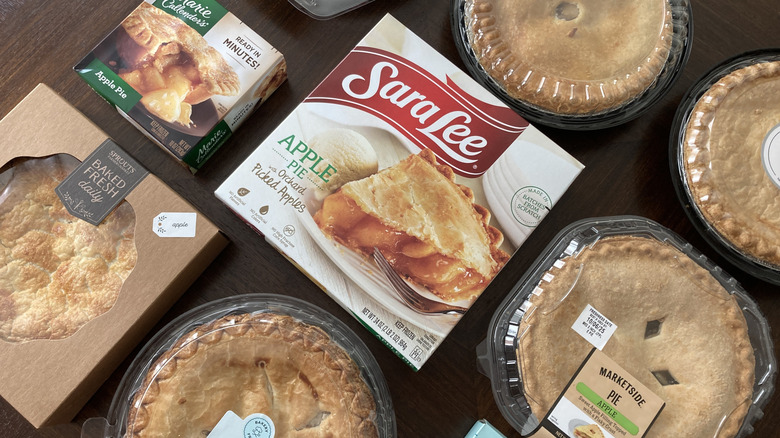 variety of grocery store apple pies on wooden table