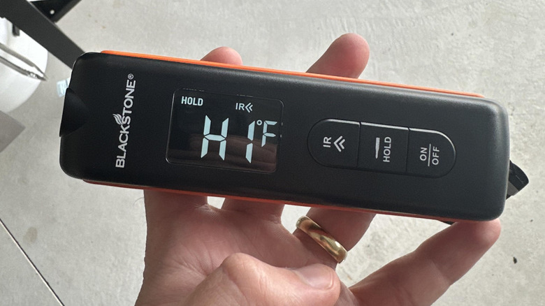 A Blackstone thermometer in a man's hand