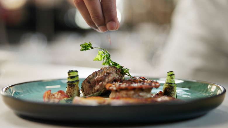 Hand seasoning plate of food