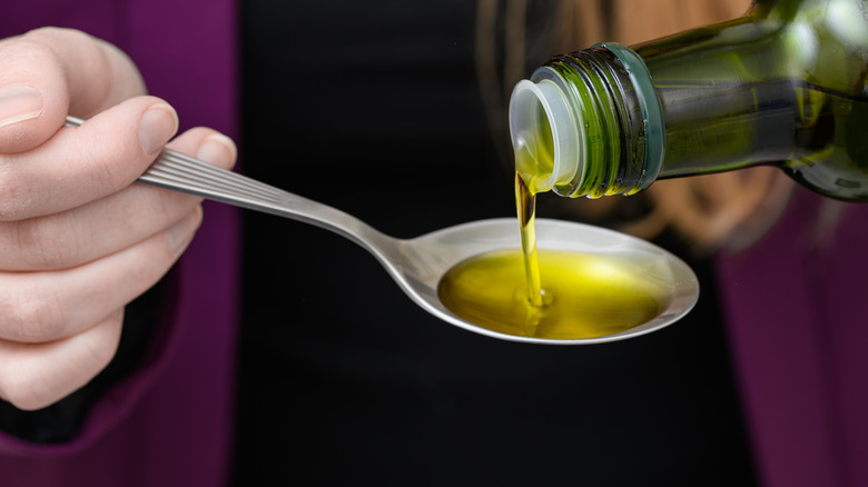 Measuring spoonful of olive oil
