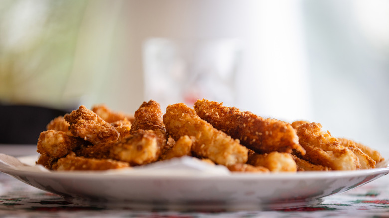 fish sticks piled on a white dinner plate