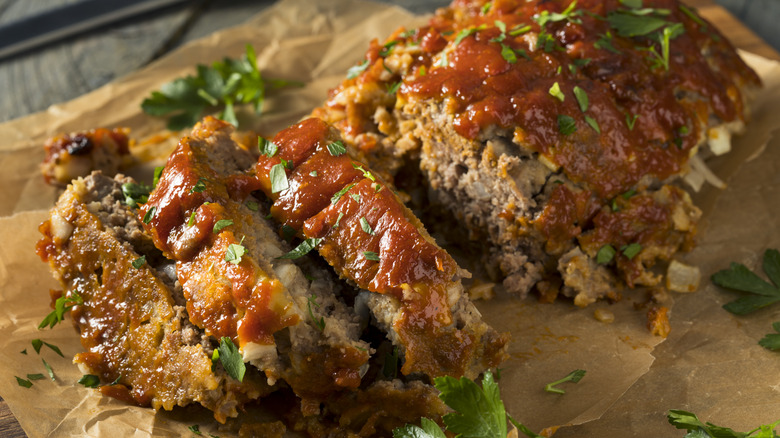 aerial photo of sliced meatloaf on top of a piece of parchment paper