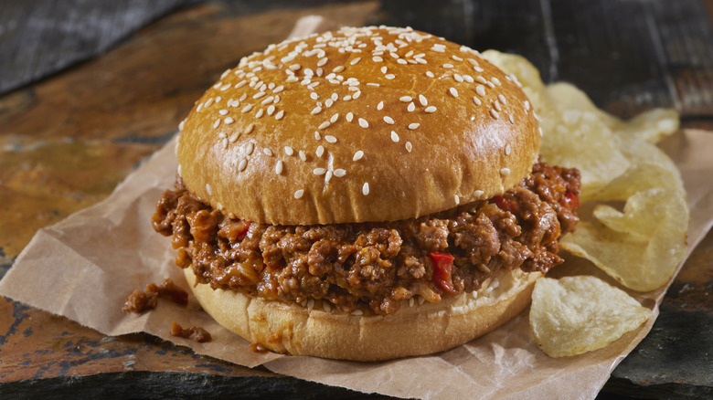 sloppy joe served on a hamburger bun, served with a side of potato chips