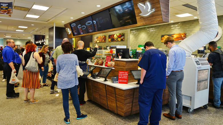 People waiting for food at a Wawa counter