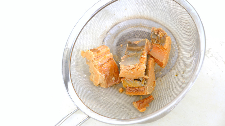 Chunks of canned salmon being drained