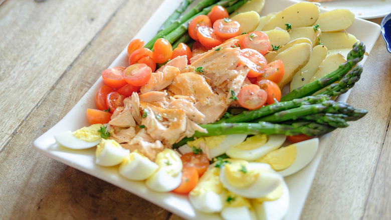 Woman preparing a salmon salad nicoise