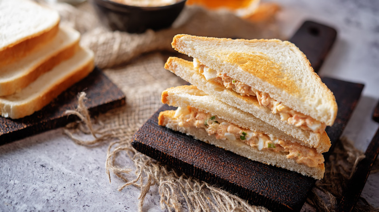 View of salmon salad sandwiches on board