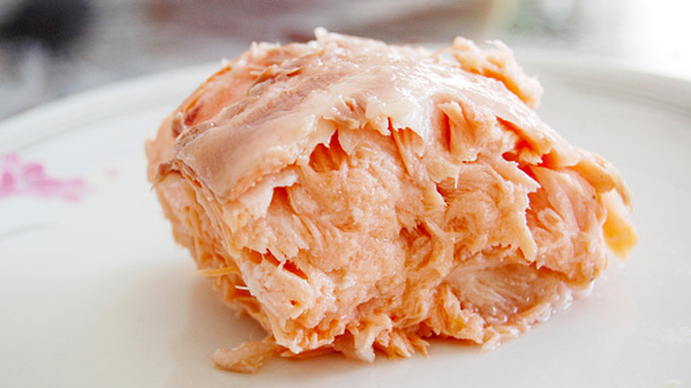 Close-up of canned salmon on a white plate without skin or bones