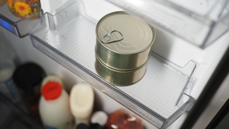 two cans in a refrigerator on the shelf
