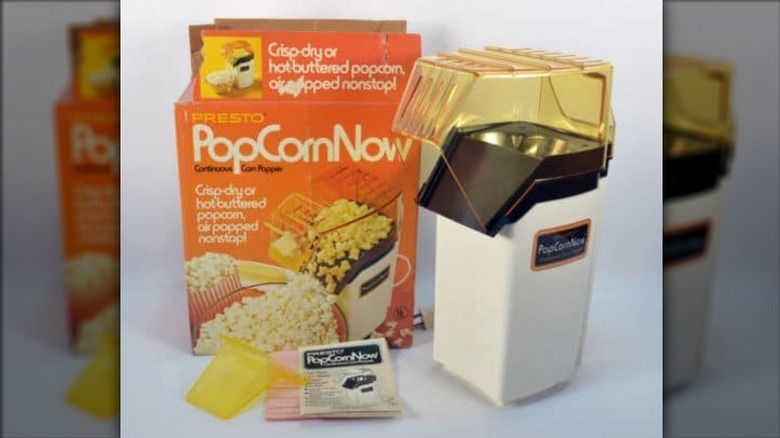 vintage Presto popcorn maker next to box on a white background