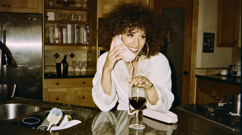 woman talking on a house phone in the kitchen