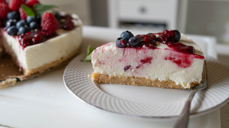 A slice of no-bake creamy set dessert topped with berries
