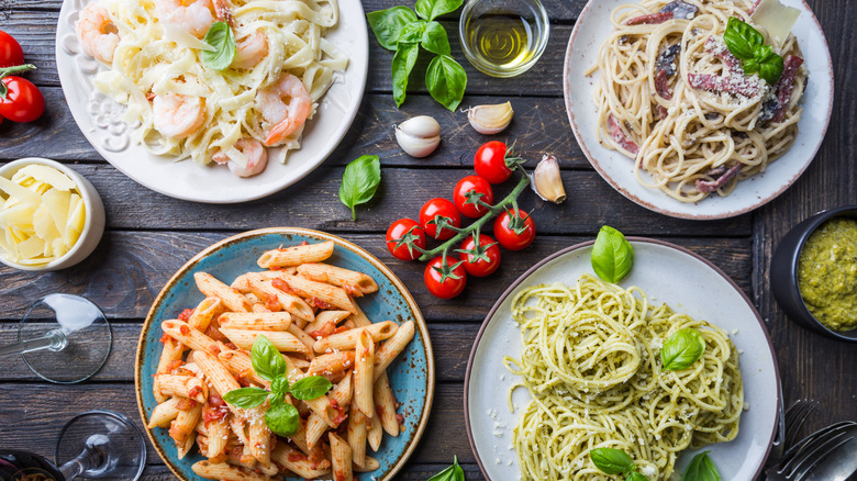Several plates of pasta on wooden table