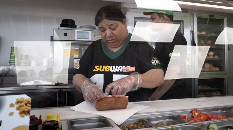 Subway employee preparing a sandwich
