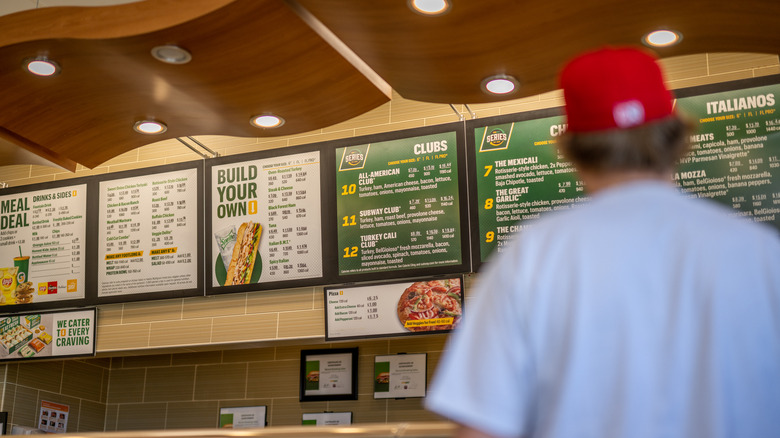 Customer looks at Subway menu