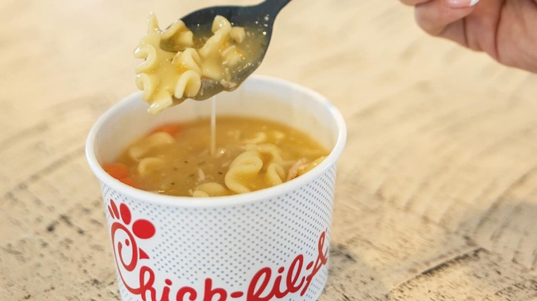 Close-up of hand holding spoonful of Chick-fil-A Chicken Noodle Soup