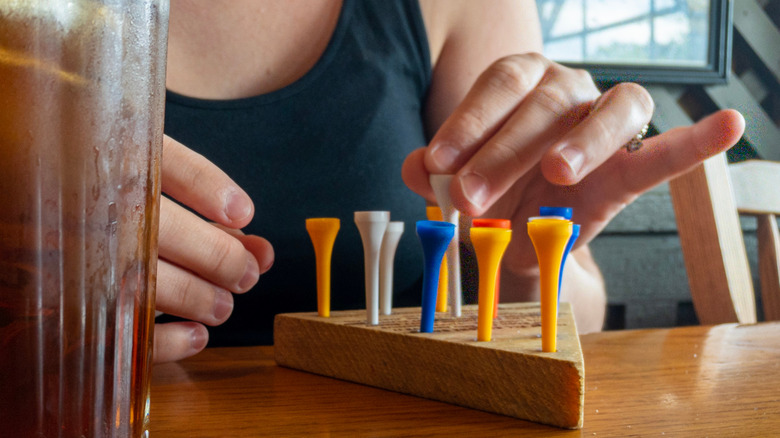 close-up of a woman's hands playing Cracker Barrel's triangle peg game