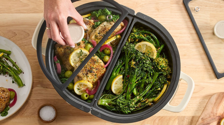 Top view of a double sided crockpot with chicken and broccoli