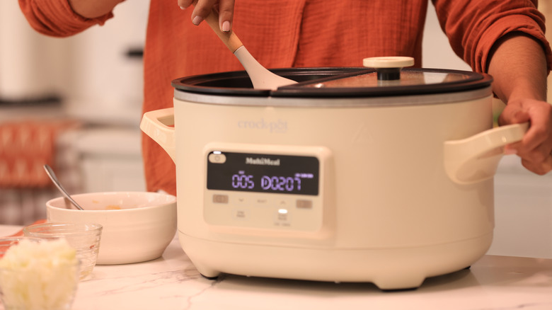 Close up of someone mixing items in crockpot