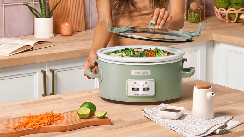 Some putting lid on green crockpot