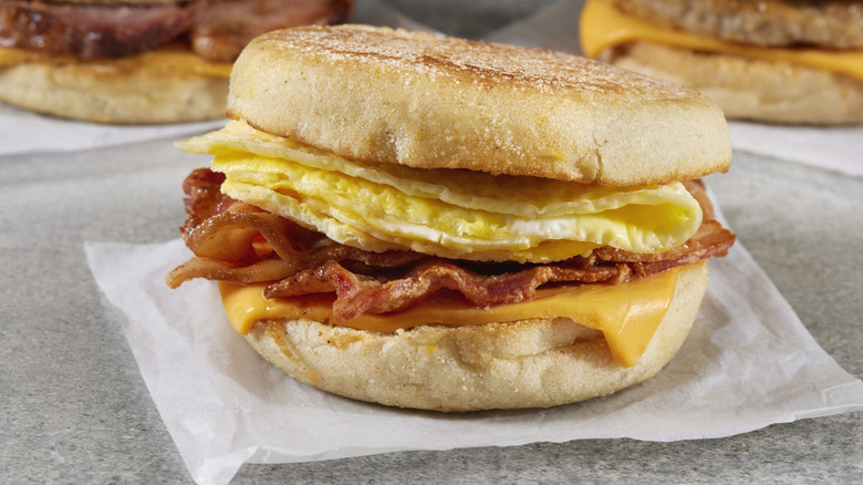 Up-close photo of a breakfast sandwich with egg, cheese, and bacon on an English muffin
