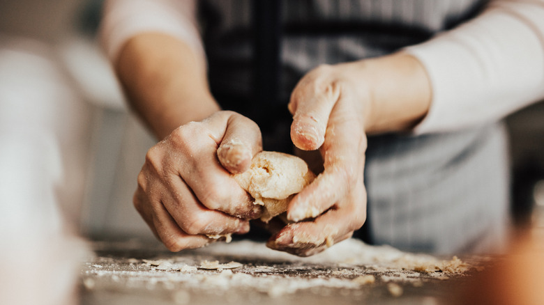 A close-up shot of hands kneading dough